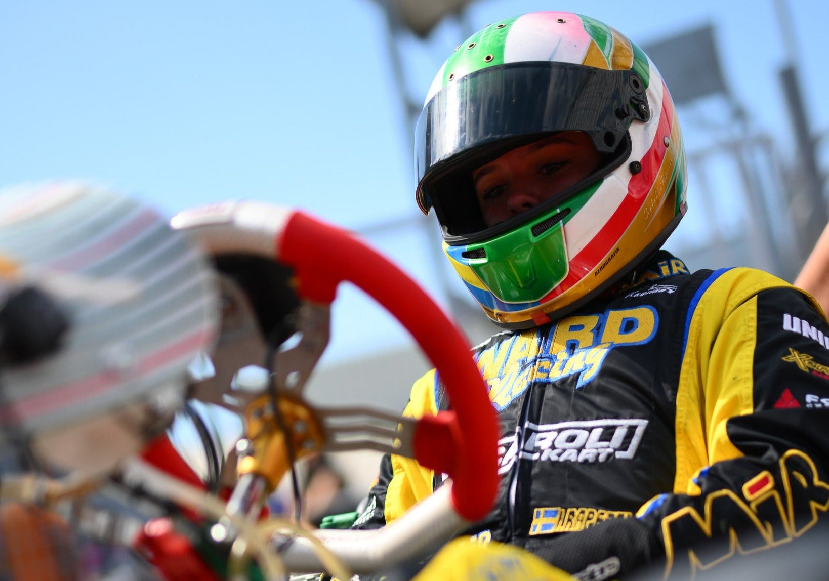 Isabella Rapezzi Dahl a Racing driver in a colorful helmet and racing suit with a kart